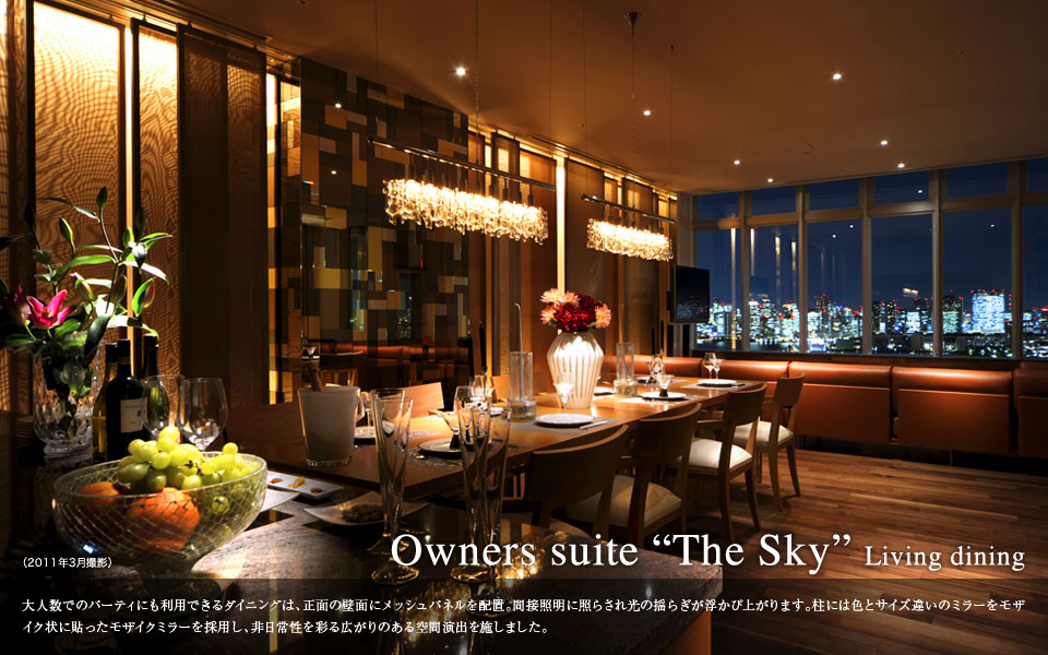 Owners suite The Sky living dining 大人数でのパーティにも利用できるダイニングは、正面の壁面にメッシュパネルを配置。関節照明に照らされ光の揺らぎが浮かび上がります。柱には色とサイズ違いのミラーをモザイク状に貼ったモザイクミラーを採用し、非日常性を彩る広がりのある空間演出を施しました。